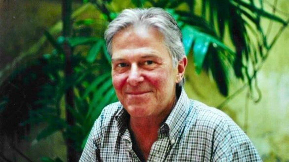 Le comédien Hubert Gagnon, dehors, qui sourit pour la photo.