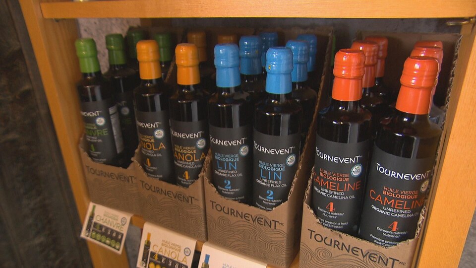 Des bouteilles d'huile Tournevent dans un présentoir.