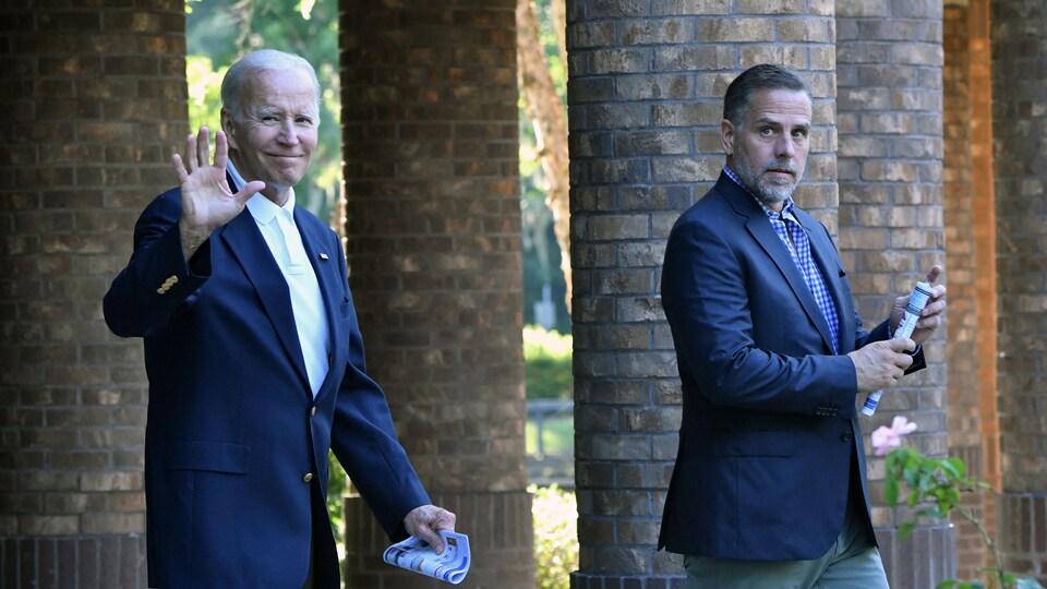 Hunter Biden (à droite sur l'image) marche avec son père, le président Joe Biden (à gauche). Celui-ci fait un signe de la main.