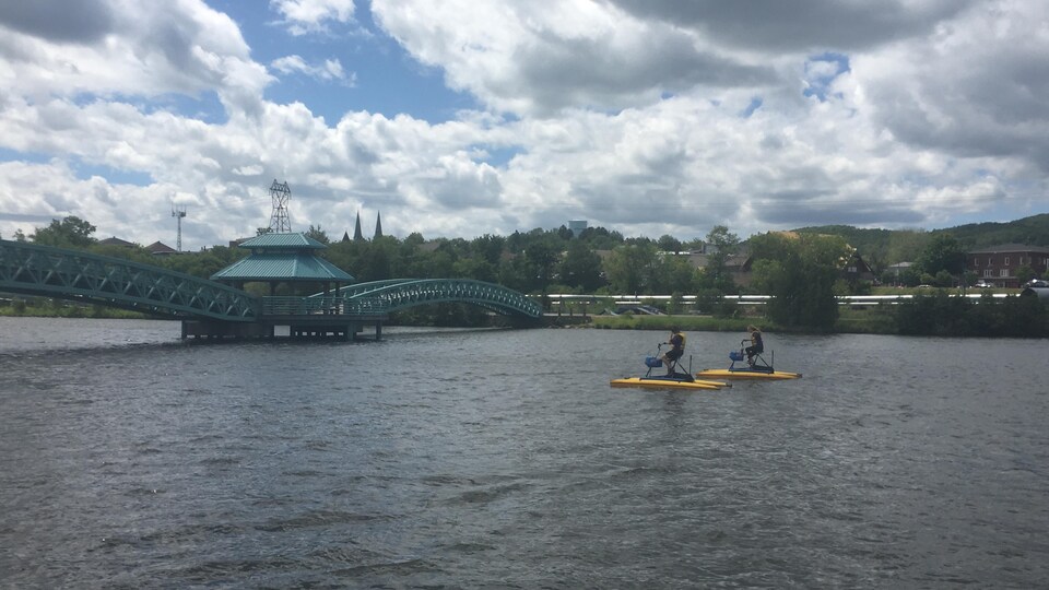 Deux résidents qui font l'essai de vélo d'eau sur la rivière Madawaska dans le secteur du centre-ville d'Edmundston.