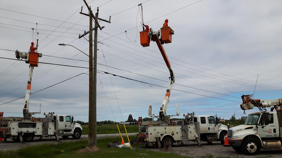 Des employés d'Hydro One effectuent des travaux sur une ligne de transmission électrique.