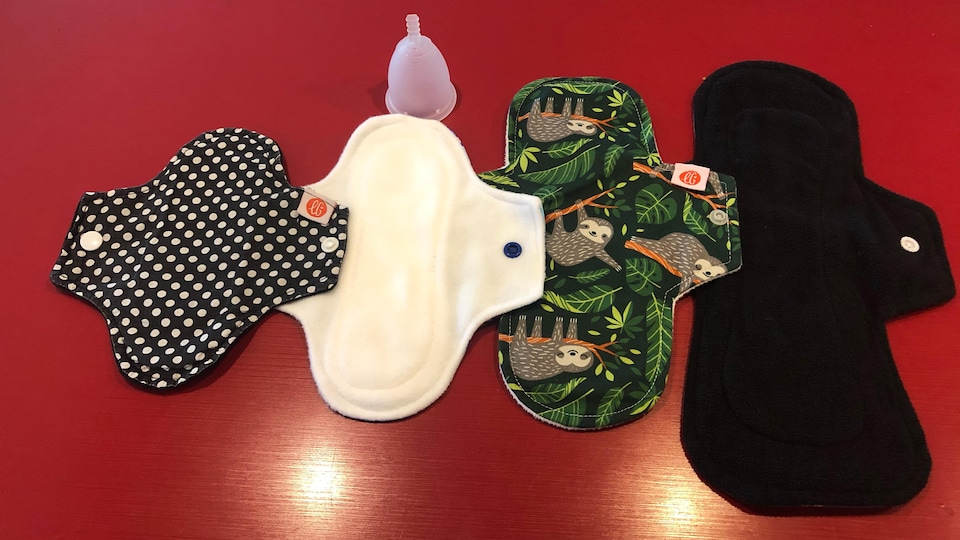 Quatre serviettes hygiéniques lavables et une coupe menstruelle.