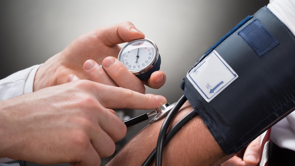 Un médecin mesure la tension d'un patient.