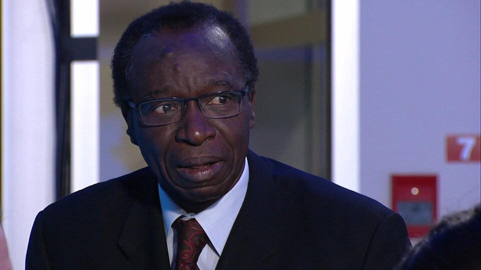 Une homme portant des lunettes parle.