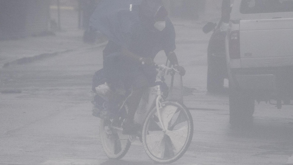 Yağmurda ve rüzgarda bisikletçi.  