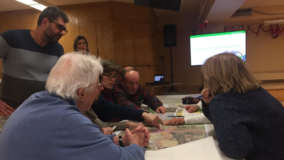 Les citoyens de Magog ont mis en commun, mardi soir, des idées de développement pour le secteur de la sortie 118. On voit ici un groupe de sept citoyens discuter autour d'une carte de la sortie 118. 