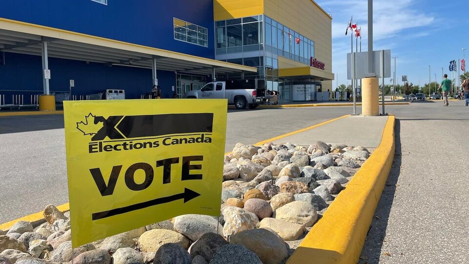 Une affiche d'Élections Canada est en gros plan, devant le magasin Ikea.