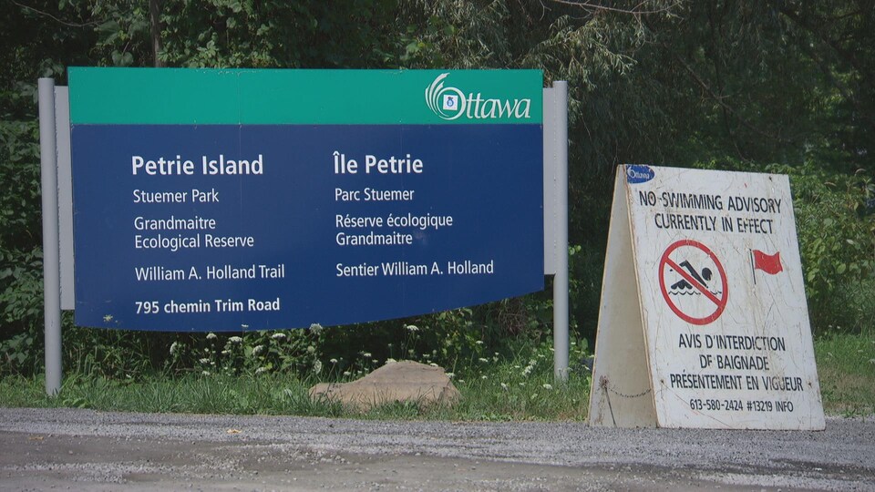 Sur l'affiche, on peut lire : « Avis d'interdiction de baignade présentement en vigueur ».
