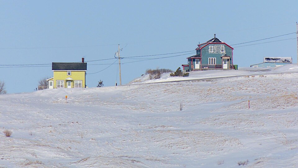 Des maisons enneigées sur une butte des Îles-de-la-Madeleine.