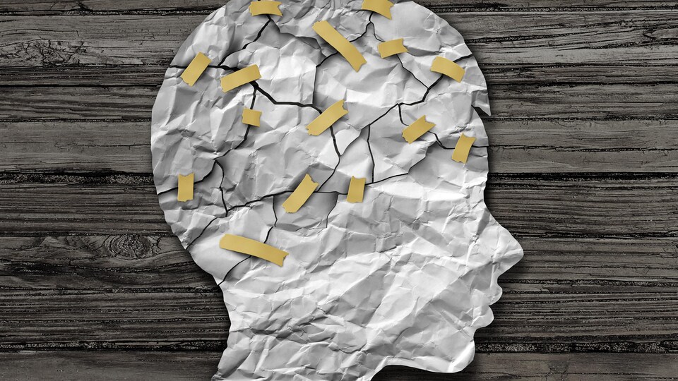 Une tête d'enfant illustrée en papier avec les éléments du cerveau reliés par des rubans gommés
