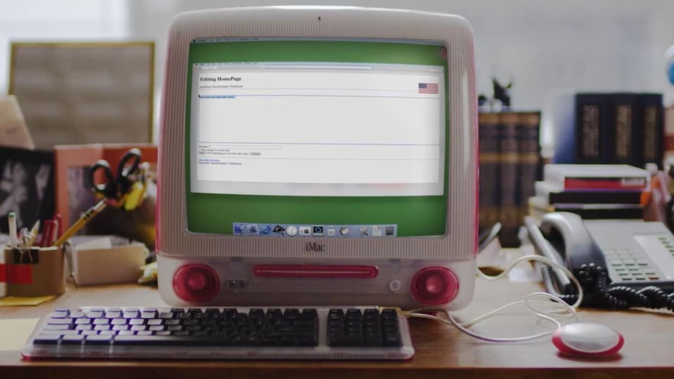 Un ordinateur iMac trône sur un bureau. Il est allumé sur la première page Wikipédia datée du 15 janvier 2001.