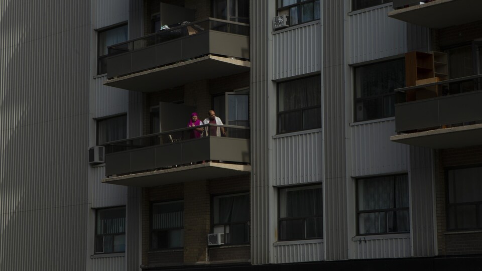 Un couple à son balcon.