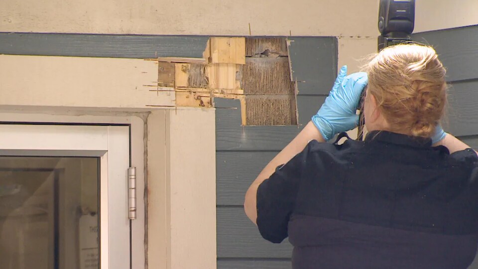 An officer photographed a bullet hole in a door frame.
