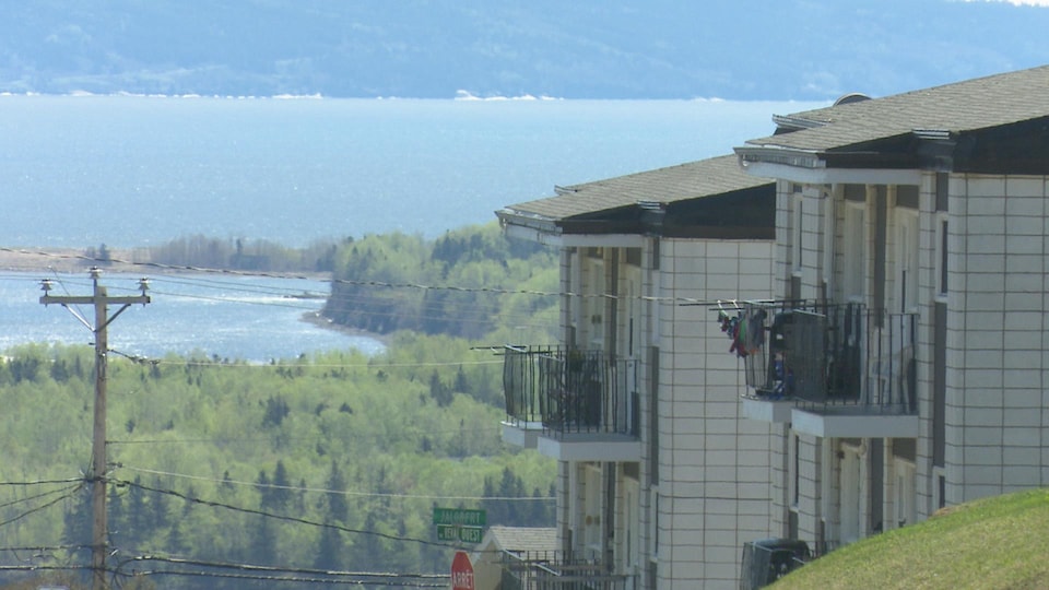 Deux immeubles de logements se dressent devant la baie de Gaspé.