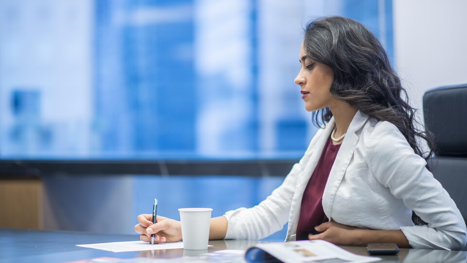 Une femme prend des notes dans un bureau.