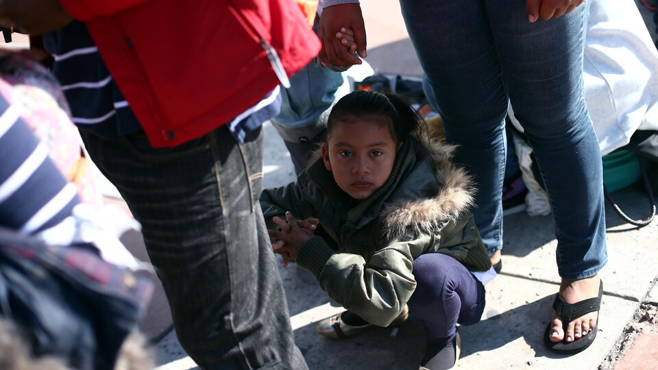 Une jeune fille, membre de la caravane des migrants en provenance de l'Amérique centrale, attend de pouvoir franchir la frontière américaine avec sa famille.