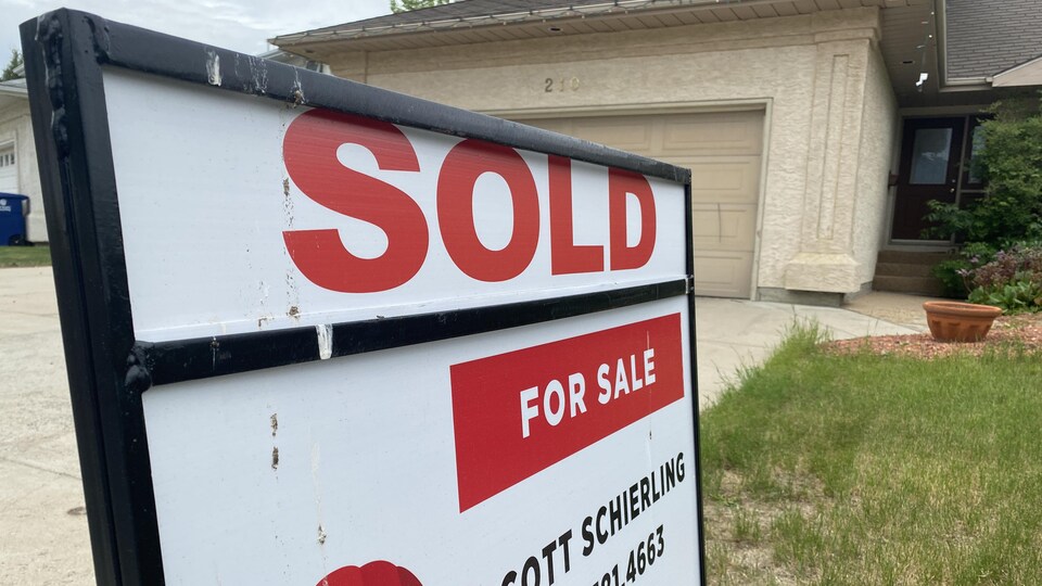 Une pancarte annonçant qu'une maison en vente a été vendue (« Sold ») à Saskatoon, en Saskatchewan, en juin 2022.