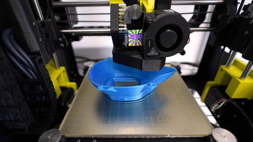 La partie d'un masque en plastique est en train d'être produite à l'aide d'une imprimante 3D.