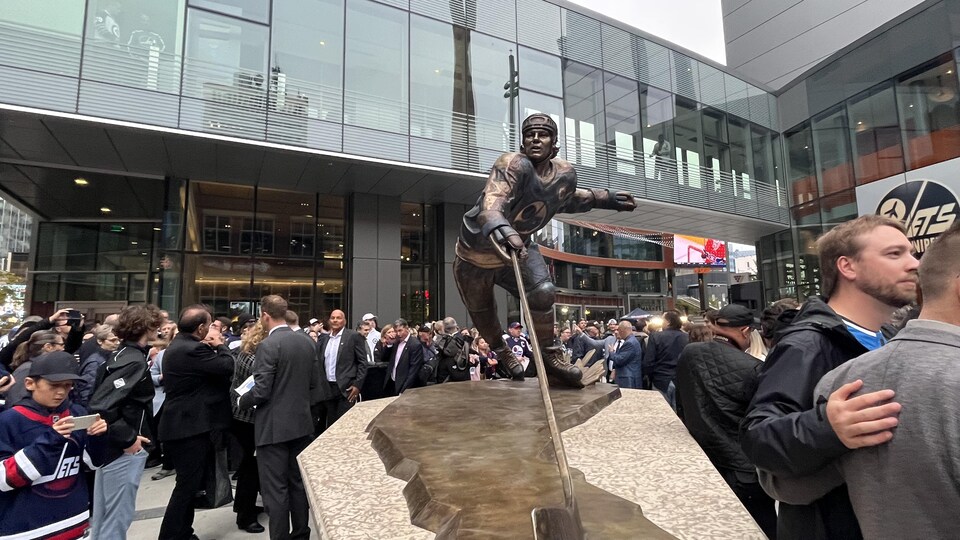 Des personnes rassemblées autour d'une sculpture dans une place publique à Winnipeg le 1er octobre 2022.