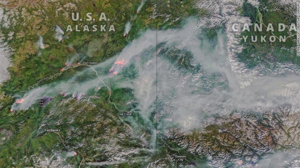 Une image satellite de la frontière entre l'Alaska et le Canada montre de la fumée et des zones de feux de forêt.