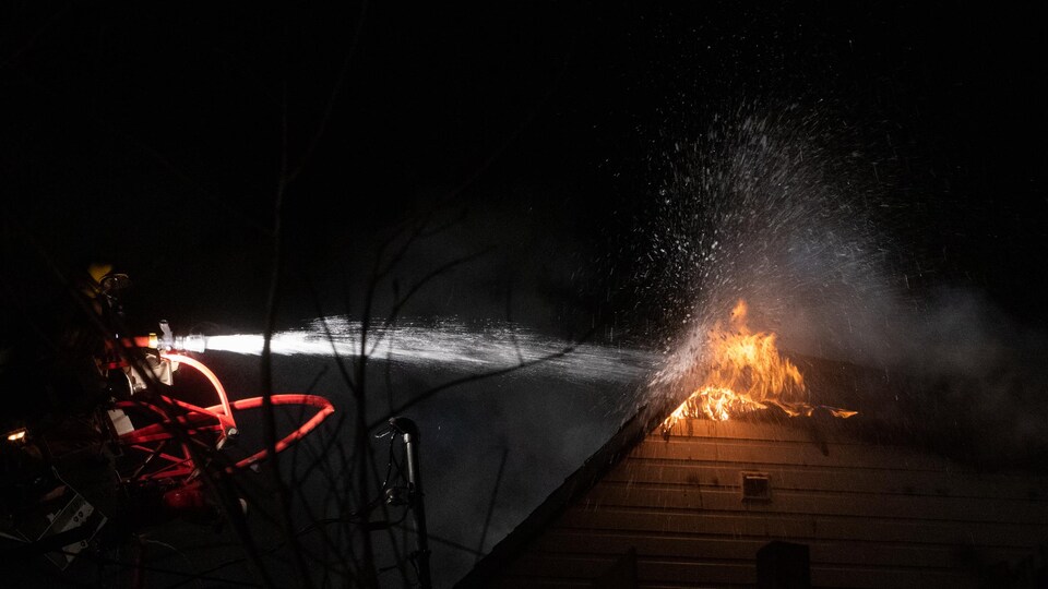 A firefighter is fighting the fire in Château-Richer.