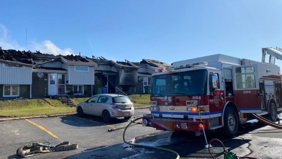 A fire truck in front of the burned houses.