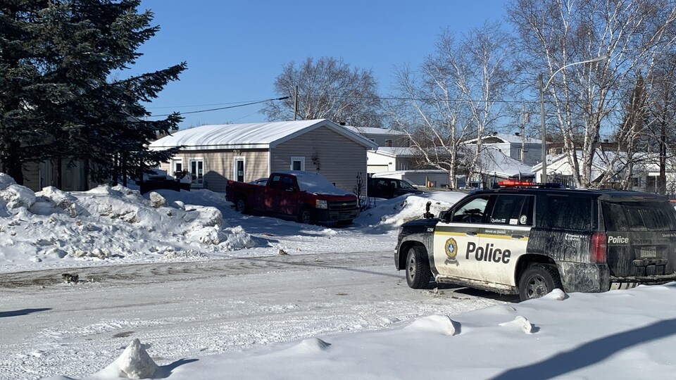 Une voiture de la Sûreté du Québec bloque une partie de la rue près d'une maison.