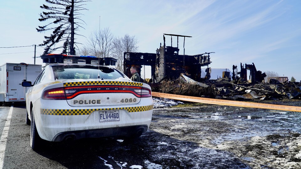 Une autopatrouille est garée non loin de la maison complètement démolie.