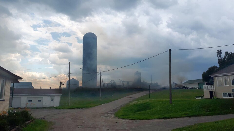 Une ferme est en fumée. Elle est complètement détruite.