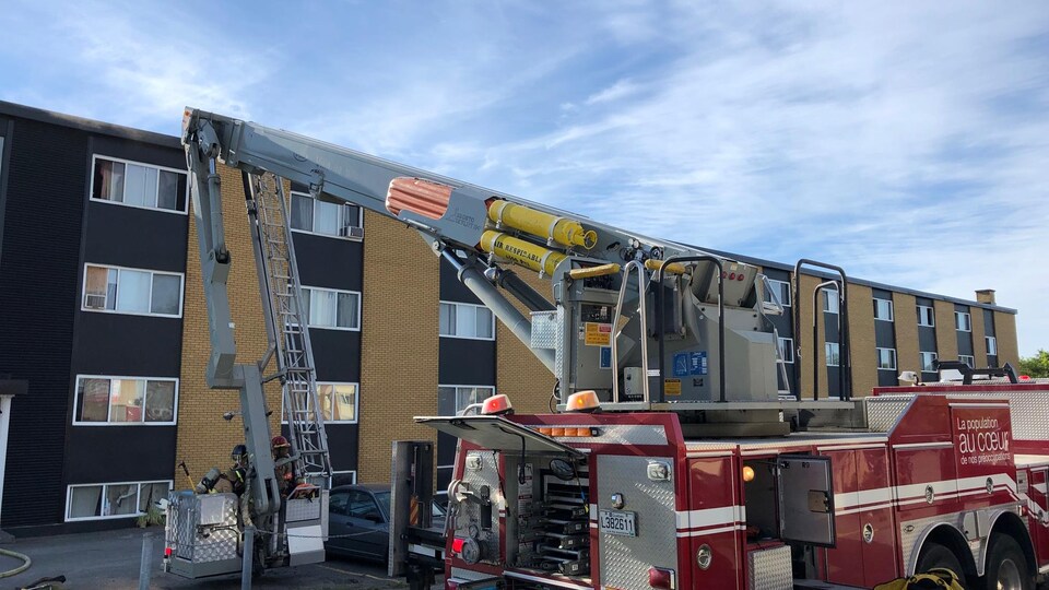Camion de pompiers devant un immeuble.
