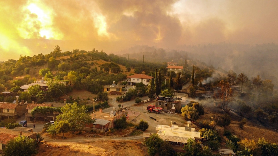 Photo aérienne montrant des maisons entourées par un incendie sur la côte sud de la Turquie, près de la ville de Manavgat.