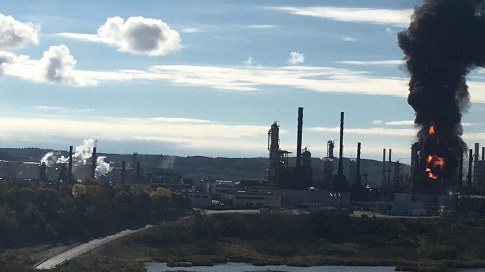 La fumée monte dans le ciel au-dessus de la raffinerie.