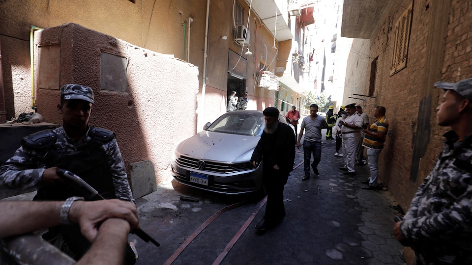 Des membres des services de sécurité dans une ruelle en Égypte après un incendie.