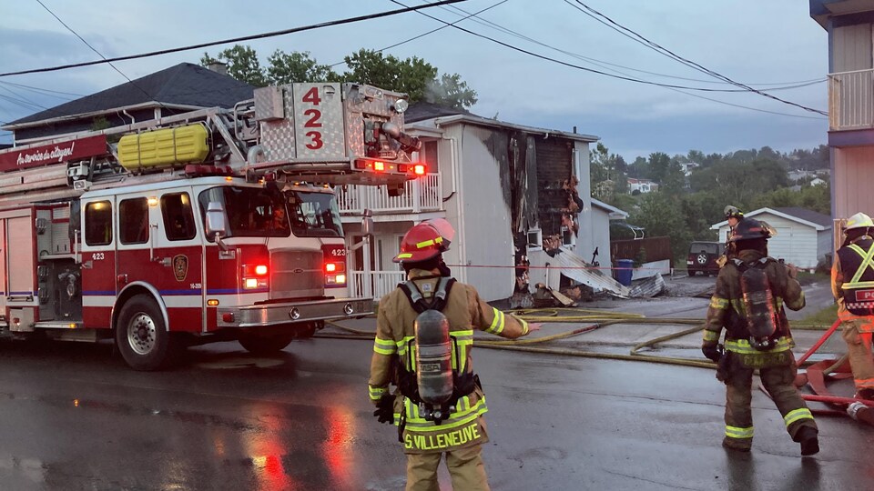 Des pompiers interviennent pour éteindre un duplex en feu.