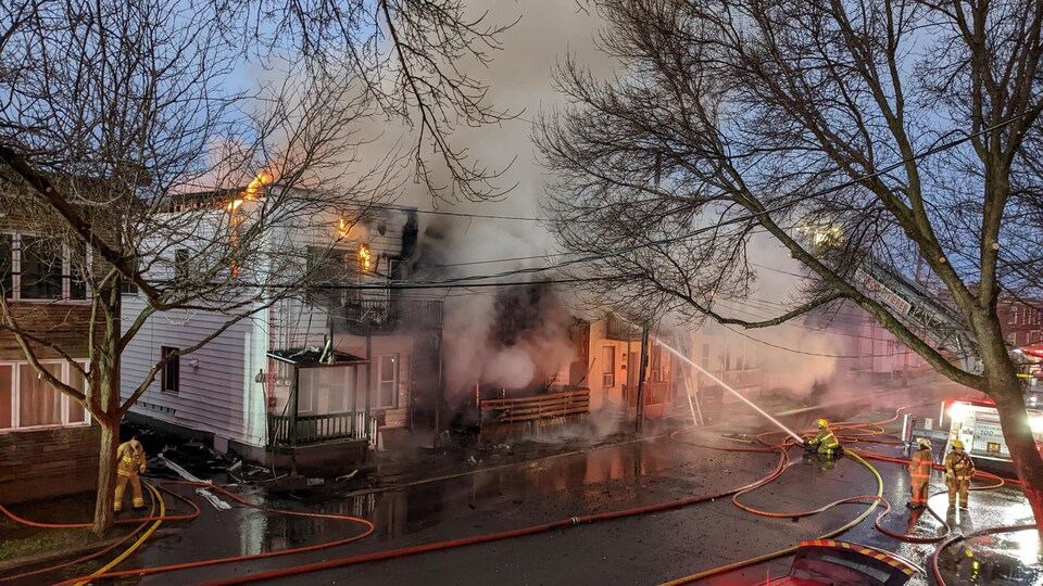 Des pompiers tentent d'éteindre un brasier.