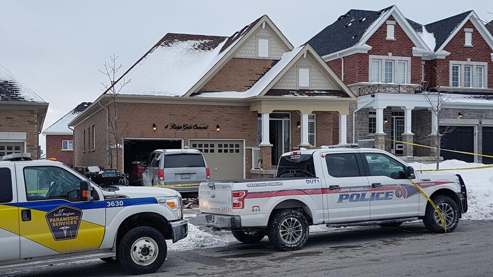 Des véhicules d'urgence stationnés devant une maison