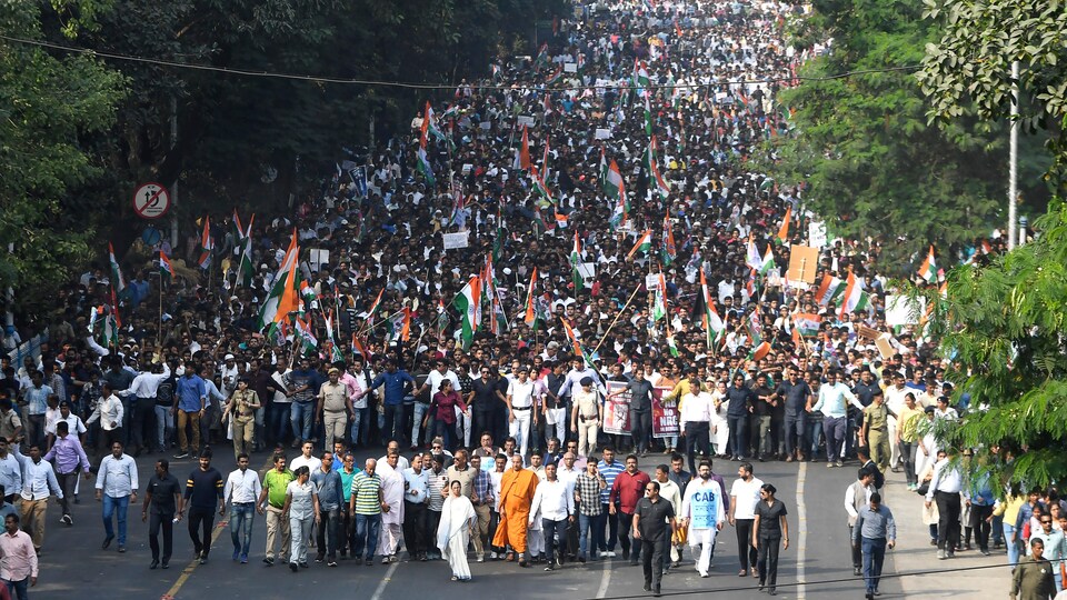 Des milliers de personnes marchent derrière Mme Banerjee.