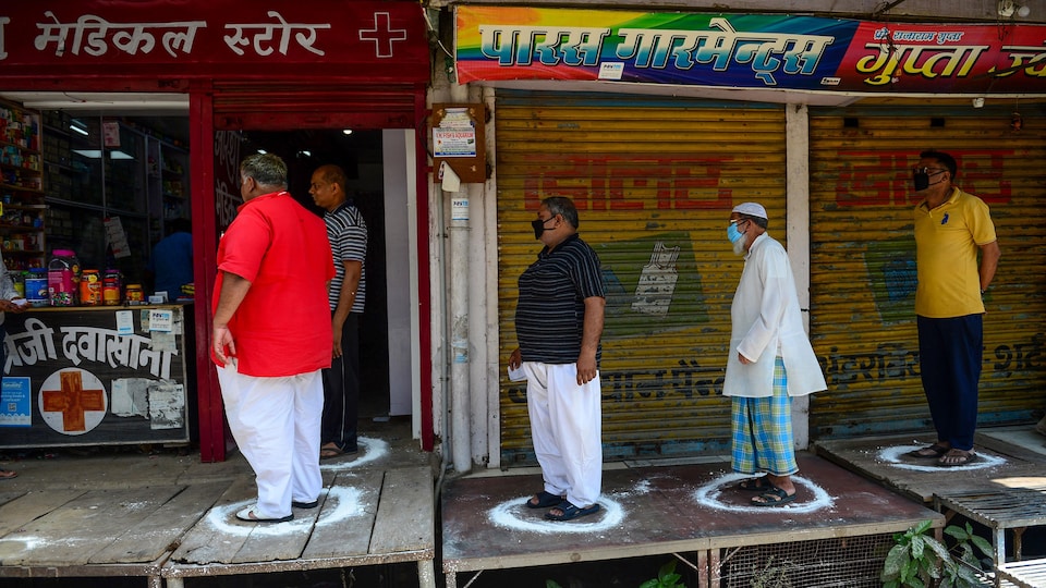 Des Indiens debout dans des cercles dessinés au sol devant un magasin.