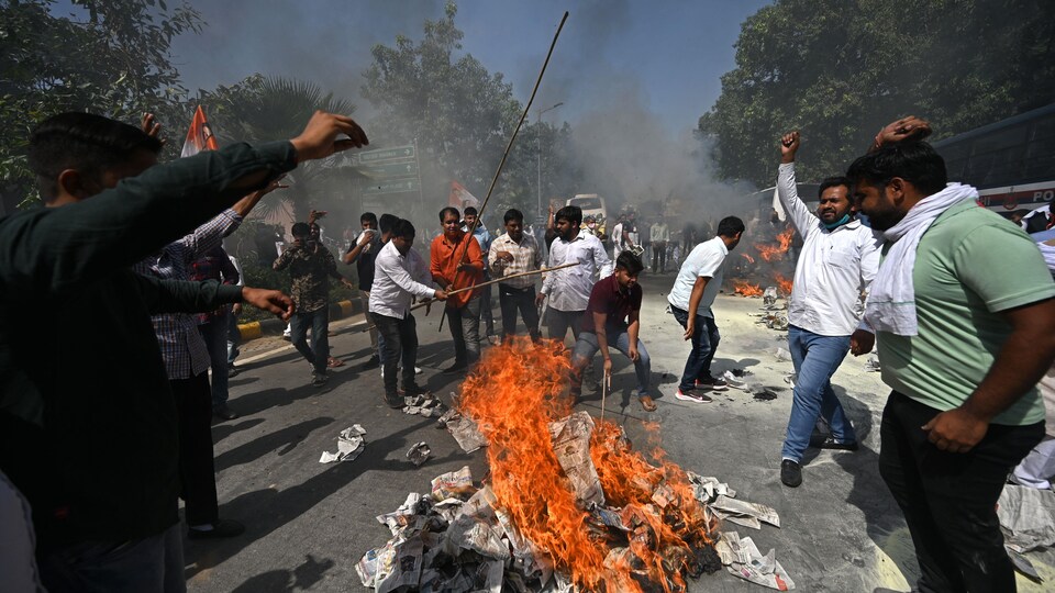 Des manifestants autour d'un feu dans la rue.