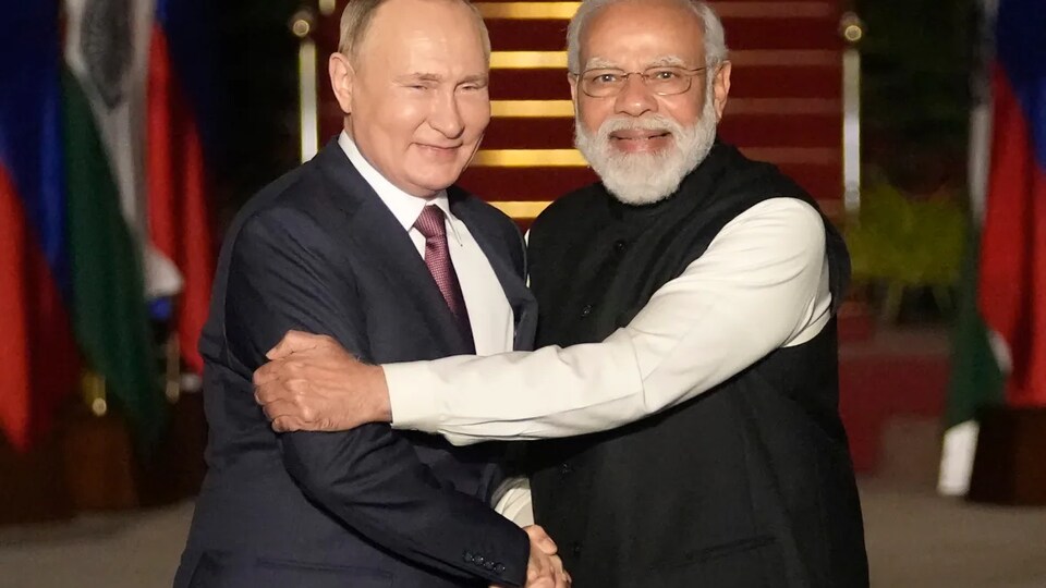 Les deux hommes se serrent la main et sourient.
