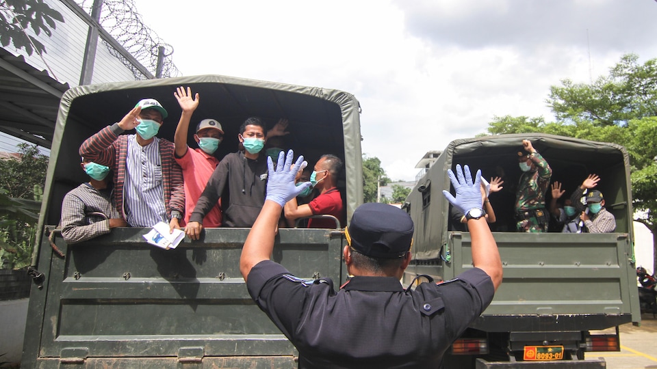 Des détenus libérés prennent place dans des camions.