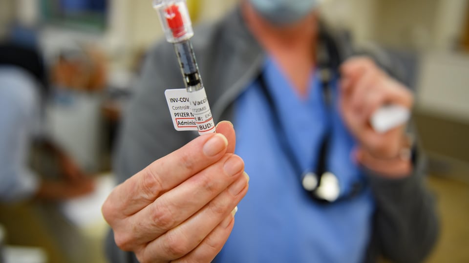 Une infirmière tient une fiole qui contient le vaccin de Pfizer-BioNTech.