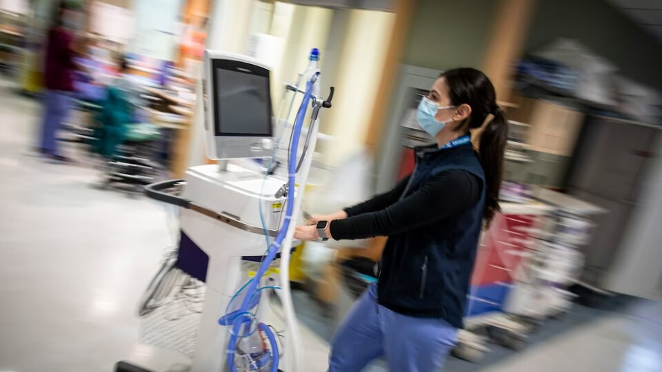 Une infirmière pousse un chariot dans un hôpital.