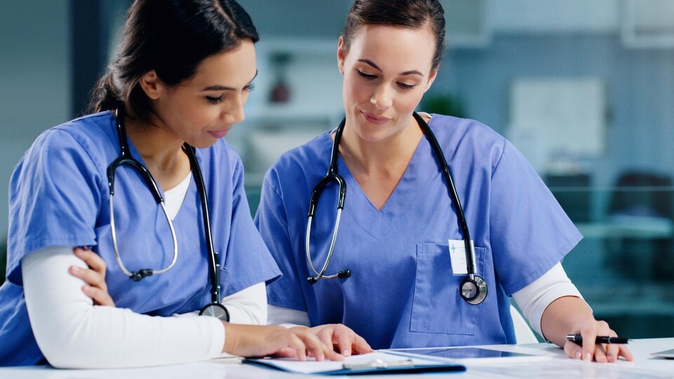 Deux infirmières discutent à l'hôpital.
