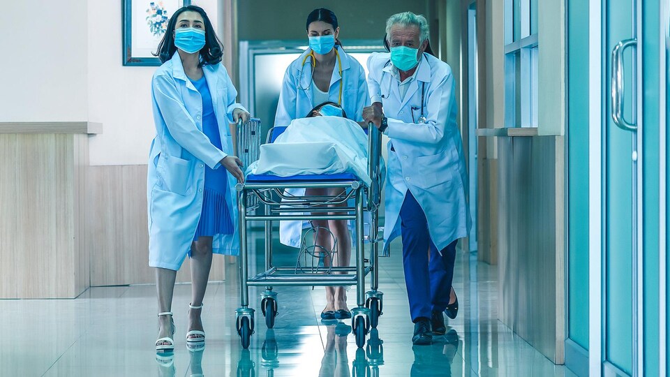 Des infirmiers poussent une civière.