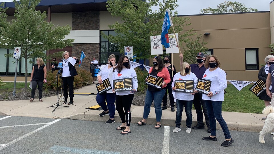 Un groupe d'infirmières avec des affiches.