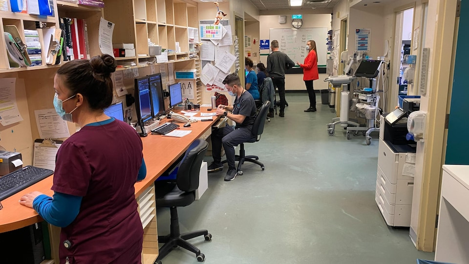 Des infirmières et des infirmiers consultent des ordinateurs à une station de travail de l'Hôpital de Rouyn-Noranda.