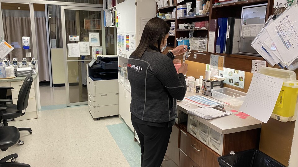 Marilie Hudon porte une veste des soins intensifs et fait passer du liquide d'un flacon à une seringue à l'Hôpital de Rouyn-Noranda.