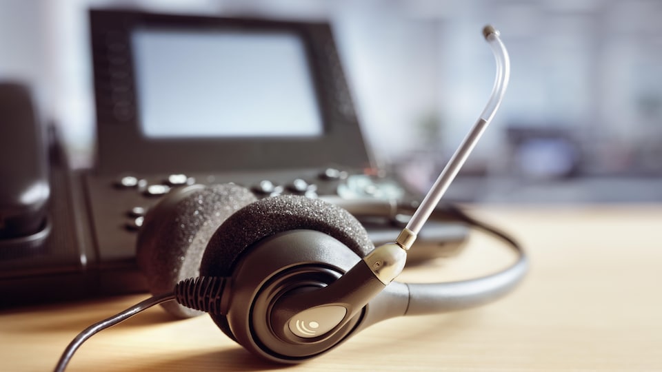 Un téléphone avec un casque d'écoute et un micro intégré.