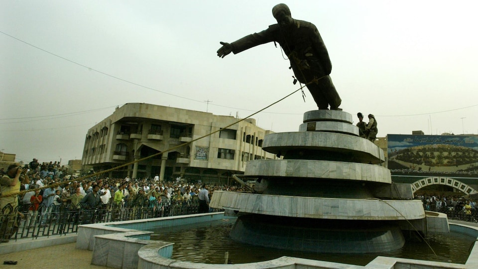 Des citoyens abattent la statue de Saddam Hussein.